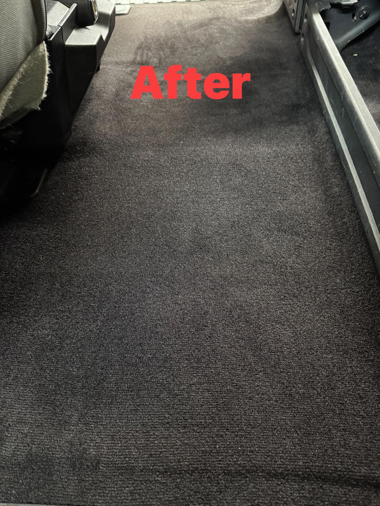 Vehicle rear carpet after detailing with a clean, restored finish.
